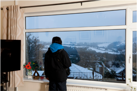 man looking out of a snowy window